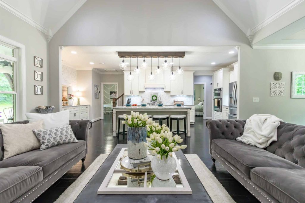 Open Floor Plan With Grey Couches And Bar With Stools