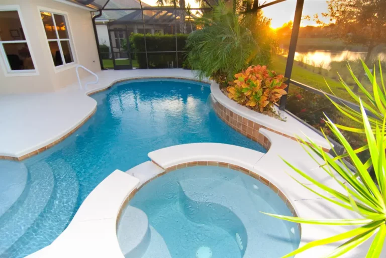 Beautiful pool surrounded by vibrant plants and landscaping, showcasing ideal materials for poolside surfaces on Florida’s Treasure Coast.